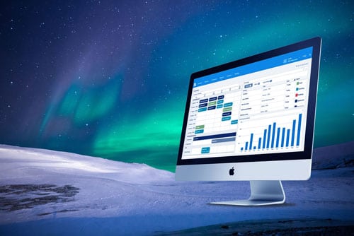 iMac som viser et bookingsystem med fjell og nordlys i bakgrunnen