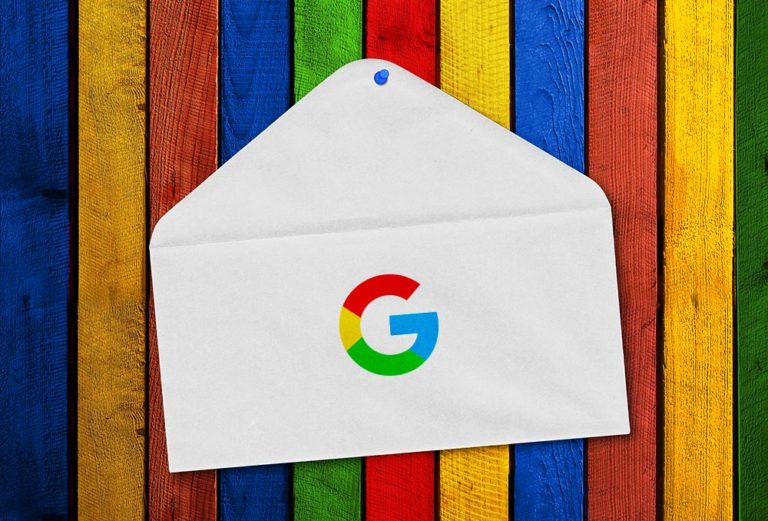 En konvolutt med Google-logoen på som ligger foran en fargerik bakgrunn. Bilde.